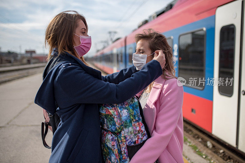 两个戴着防护面罩的妇女经过火车