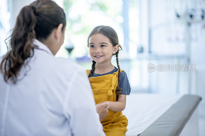 年轻的西班牙裔女孩看医生库存照片