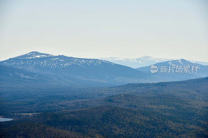 风景如画的航拍广阔的野生林地和高山与积雪覆盖的山峰。国家公园，乌拉尔，俄罗斯