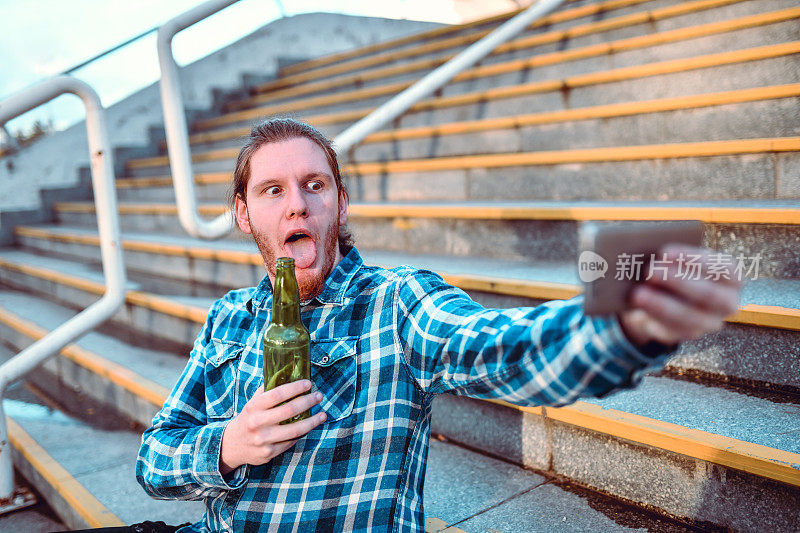 奇怪的长发男拿着啤酒瓶自拍