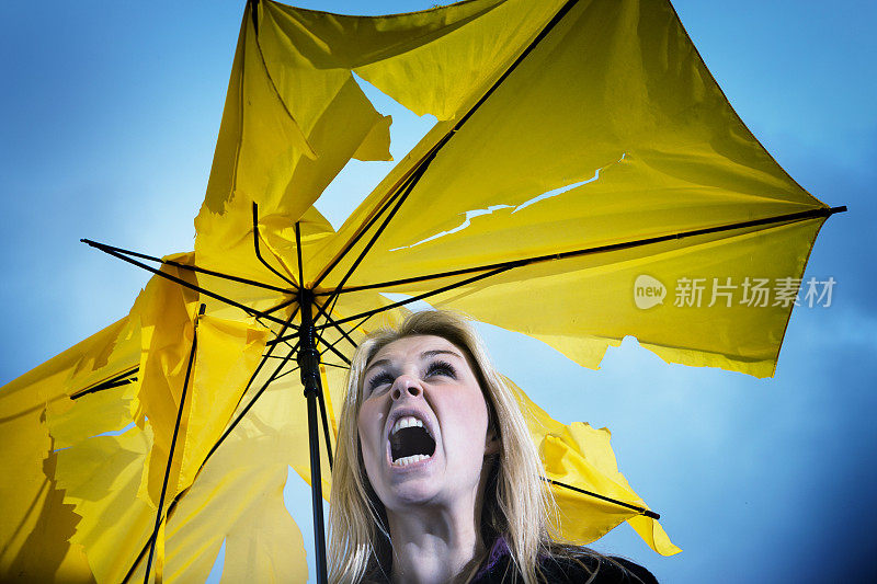 年轻女子拿着破伞对着天空大喊