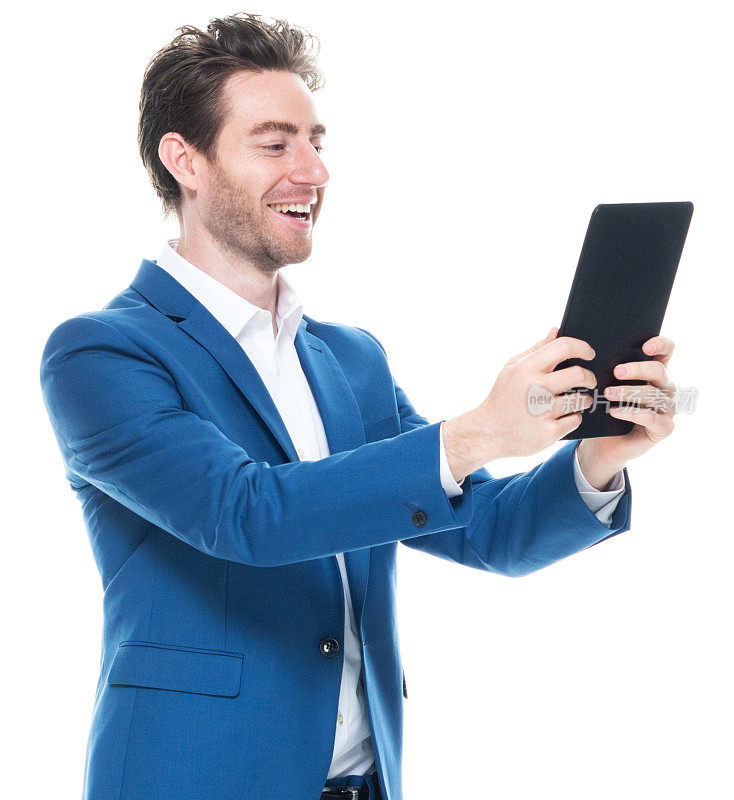 白人年轻男性商人站在白色背景前，穿着智能休闲装，使用数码平板电脑
