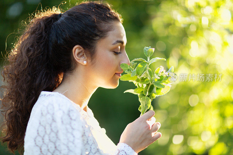 一个西班牙女人拿着一束薄荷枝