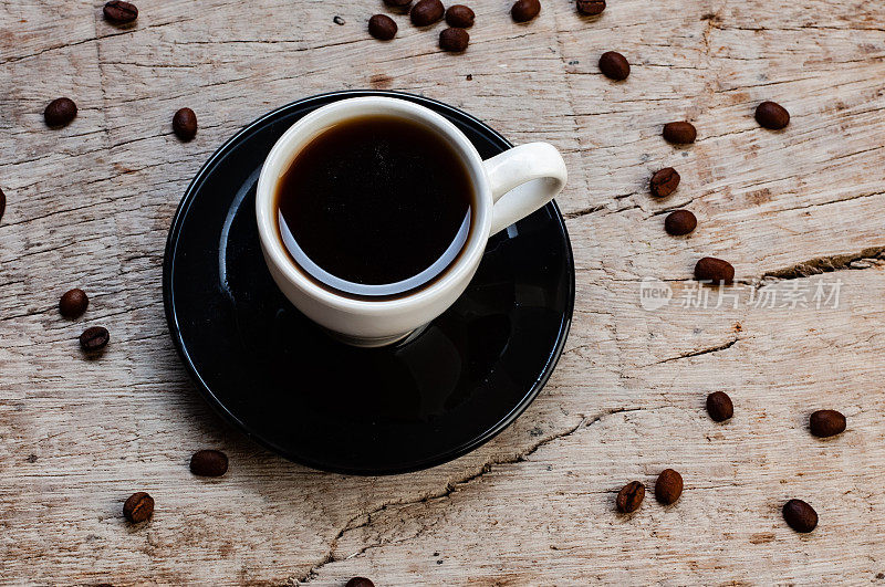 一杯热咖啡在质朴的木质背景与咖啡豆