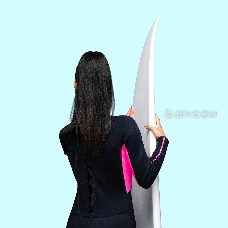 z一代女性穿着潜水服，使用冲浪板站在蓝色背景前