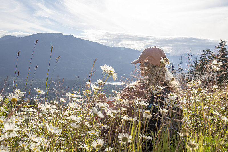 女性徒步旅行者在早晨在高山草甸放松