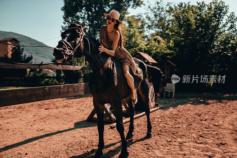 一个年轻女子在一个阳光明媚的日子里骑着马