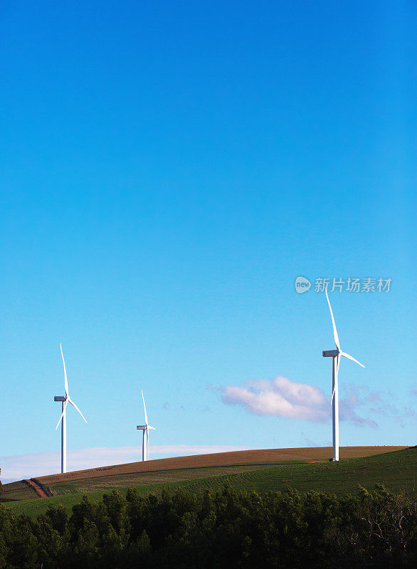 在蓝天的映衬下，农村农田里的风力涡轮机发电可再生能源