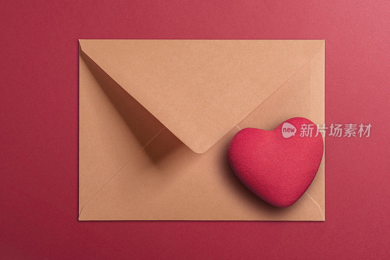 牛皮纸信封和心形在红色的背景
