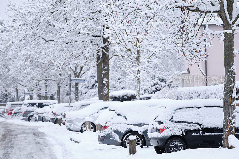 住宅区积雪覆盖的街道上停满了汽车