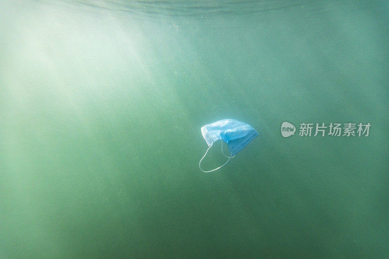 一次性口罩污染漂浮在浑浊的海水中