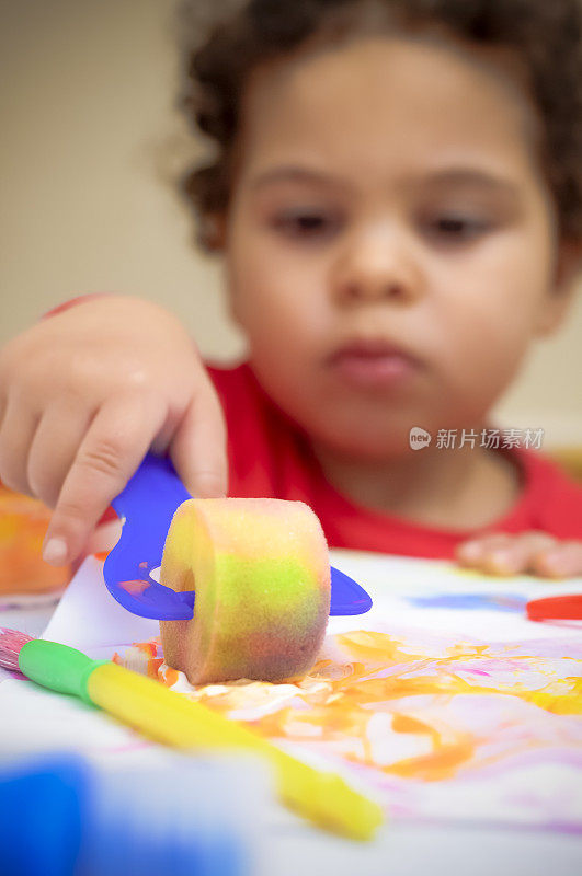 人物:孩子(2-3)在玩颜料。