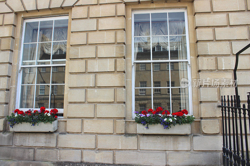 乔治时代的房子上有红色天竺葵花的窗台盒子