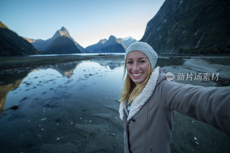 旅游的年轻女子与山景自拍