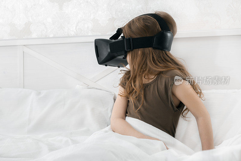 小女孩戴着VR眼镜玩网络