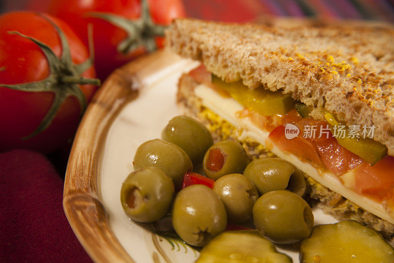 新鲜的三明治。奶酪，西红柿，泡菜，面包上的橄榄。