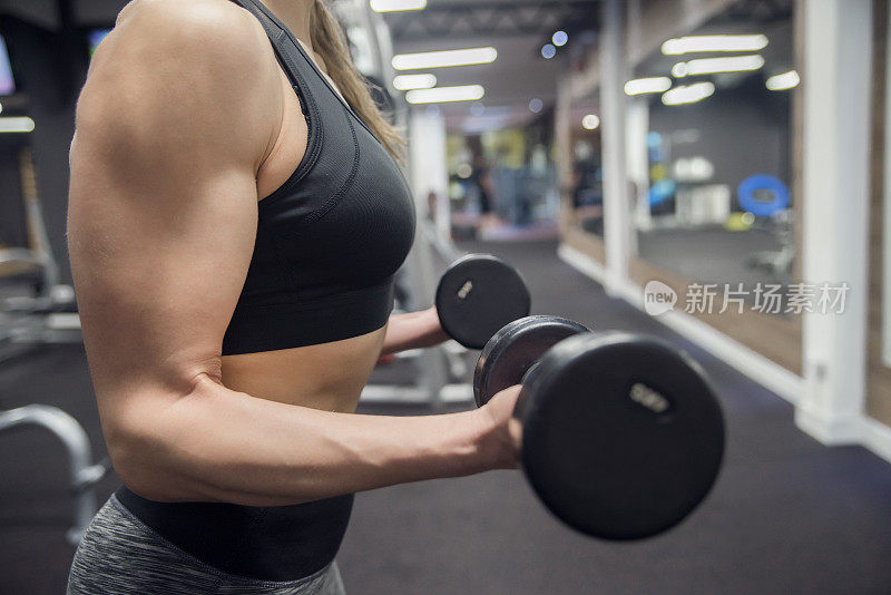 女人正在健身房用杠铃锻炼肌肉