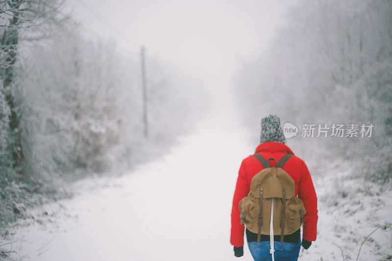 冬季运动活动。女徒步旅行者背包和雪鞋在雪地上的雪鞋