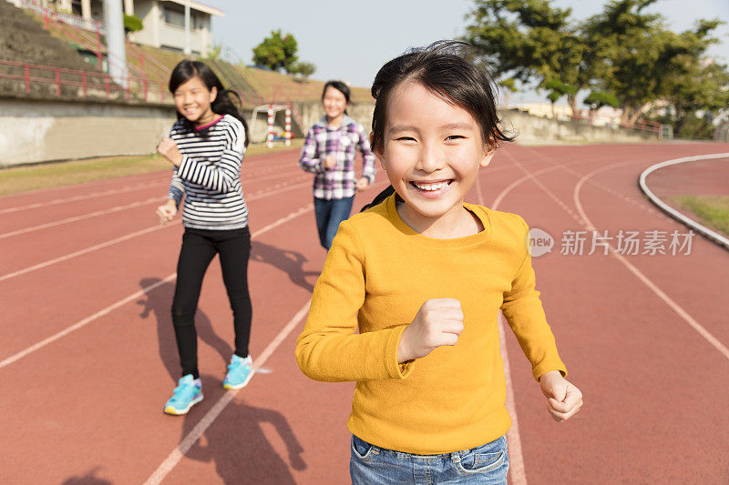 快乐的小女孩在跑道上奔跑
