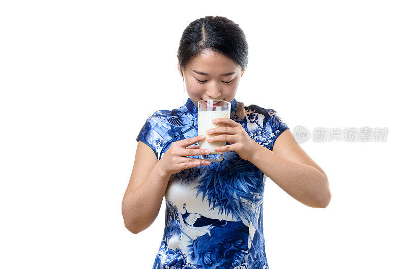 年轻的中国女子喝着一杯牛奶