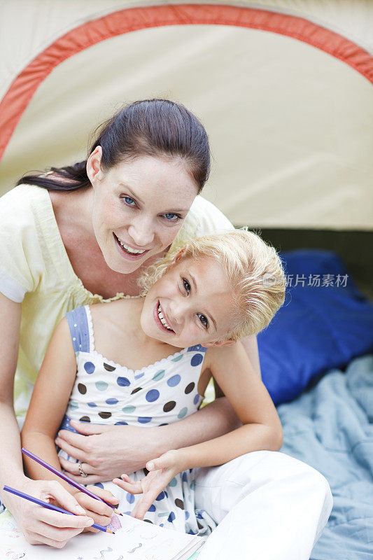 母亲和女儿在帐篷里画画