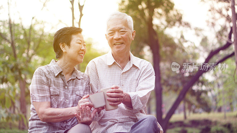 健康的亚洲老年夫妇一起在早上的公园喝咖啡