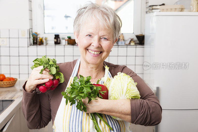 厨房里的老妇人在做蔬菜