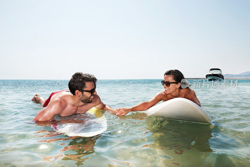 年轻夫妇在享受冲浪板。
