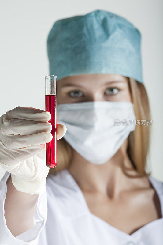 女医生展示有血的试管。