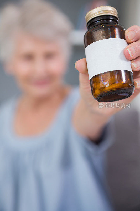退休妇女向摄像机展示她的药物