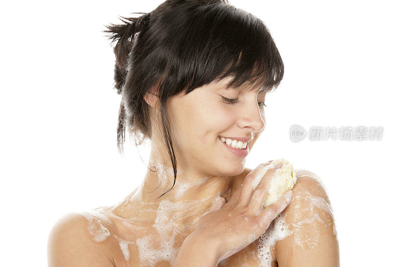 微笑的女人用海绵洗她的身体