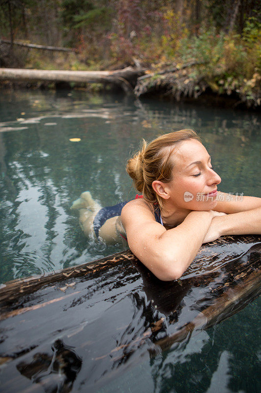在温泉中享受天然沐浴的年轻女子。
