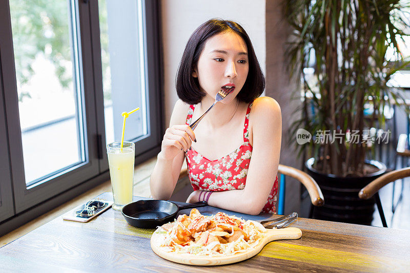 一位年轻的中国妇女正在餐馆吃午饭