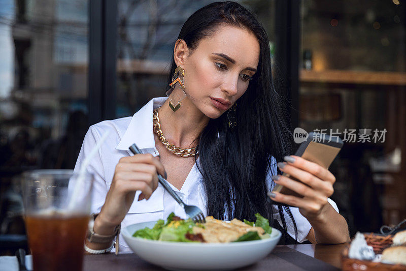 女人在午餐休息坐在户外餐厅酒吧