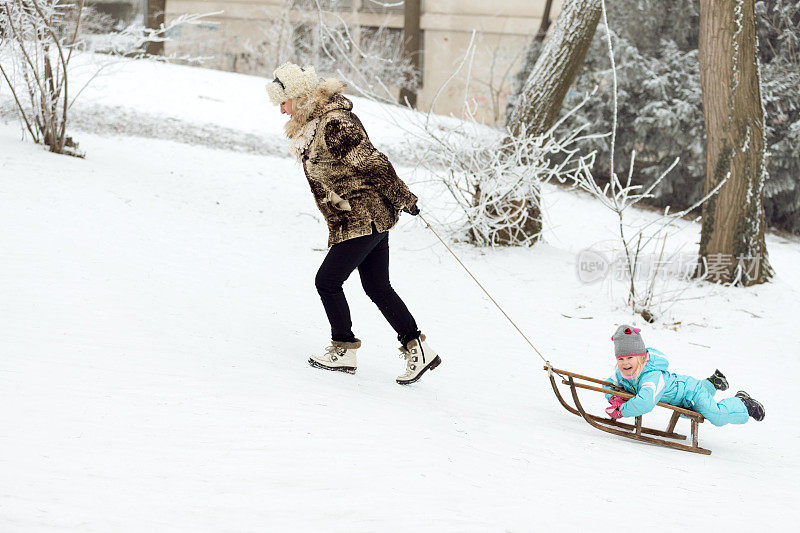 奶奶拉着小女孩坐的雪橇