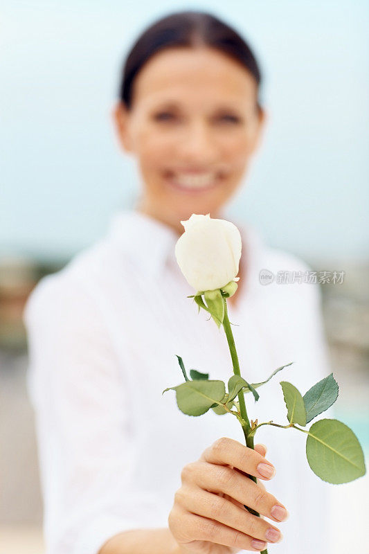 快乐的中年女士拿着一朵花