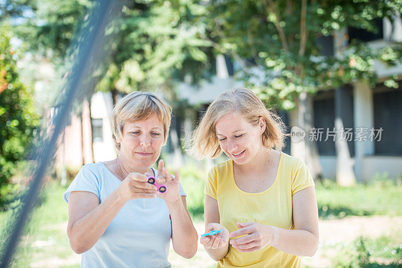 两个成熟的女人手里拿着指尖陀螺