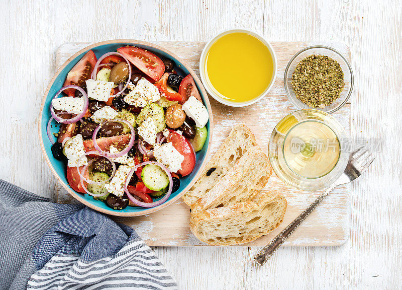 希腊沙拉配橄榄油、面包、香料和白葡萄酒