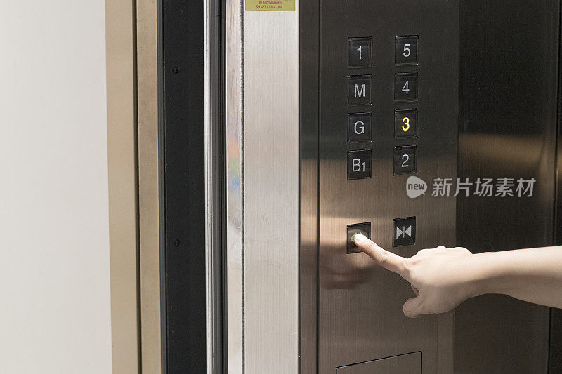 用手按住按钮打开电梯门