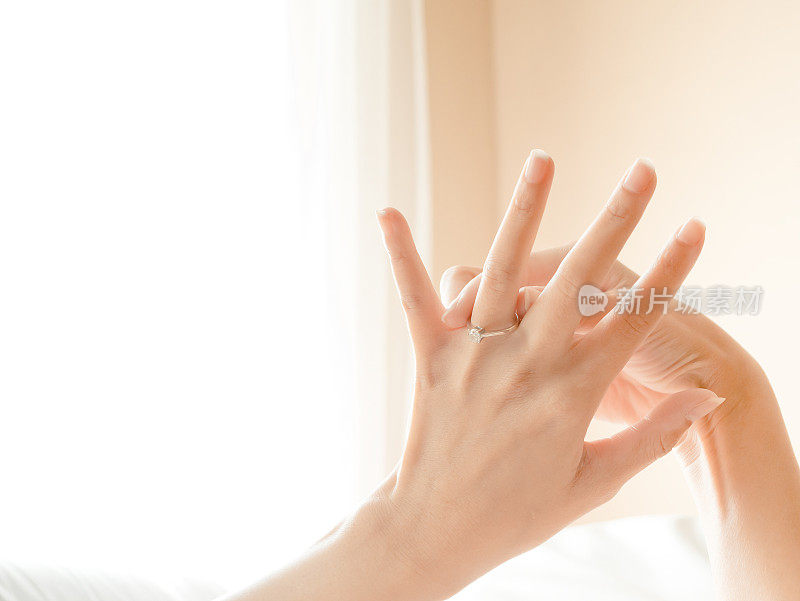 戒指戴在手指上年轻的新娘近距离，婚礼概念