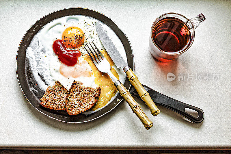 早餐，咖啡，煎蛋，在煎锅里，白色的桌子，黑色的