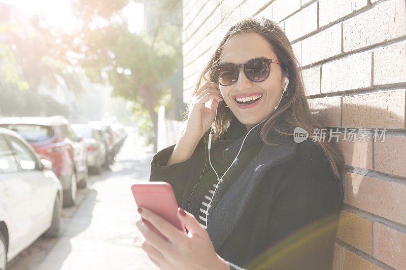 快活的女人在街上拿着手机