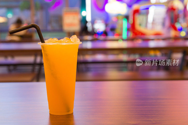 新鲜的橙汁装在玻璃杯里放在商场的木桌上