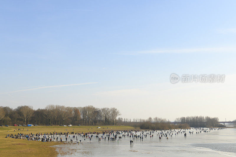 人们在兹沃勒附近的IJssel河边结冰的湖面上滑冰