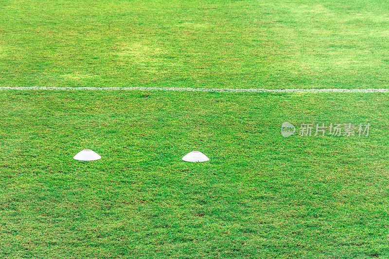 足球场里的绿草。足球场草地与体育场在蓝天的背景。