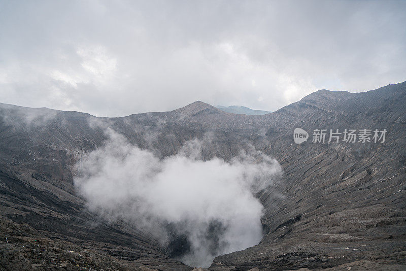 在印度尼西亚东爪哇岛的布罗莫山国家公园，布罗莫火山口边缘有蒸汽。旅游目的地冒险的自然概念