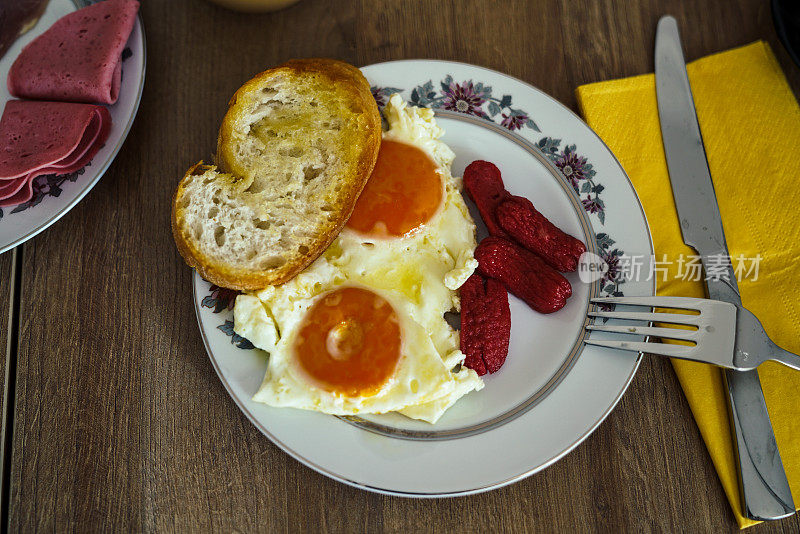 早餐桌上，面包片，香肠和煎蛋