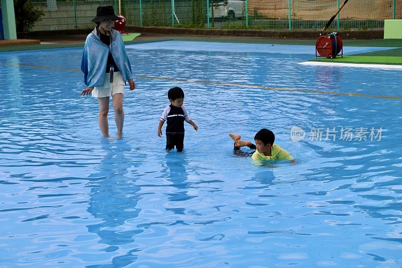 母亲和孩子在游泳池里玩耍