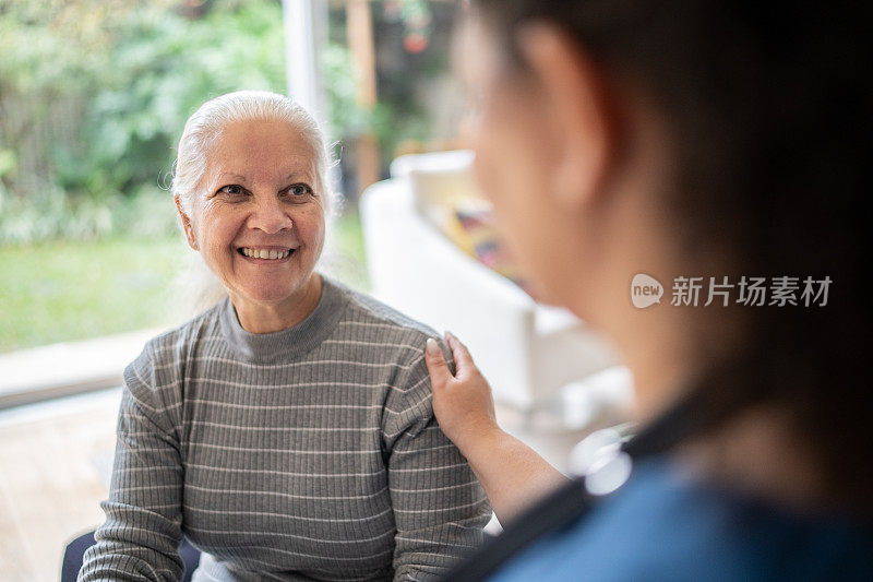 家庭护理人员在家中与老年病人交谈和安慰