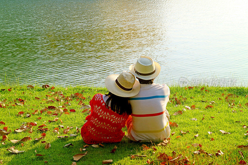 戴草帽的情侣一起在湖边放松